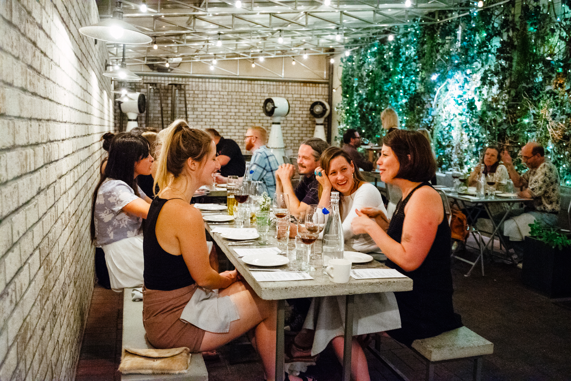 People sit at a table in a courtyard at a restaurant.