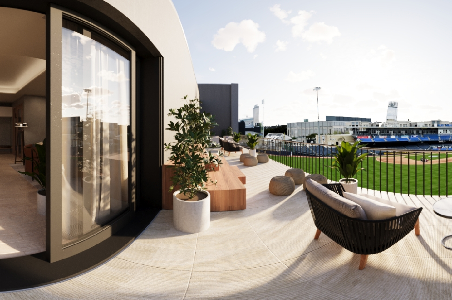 There is a balcony next to an apartment unit that looks over a baseball field.