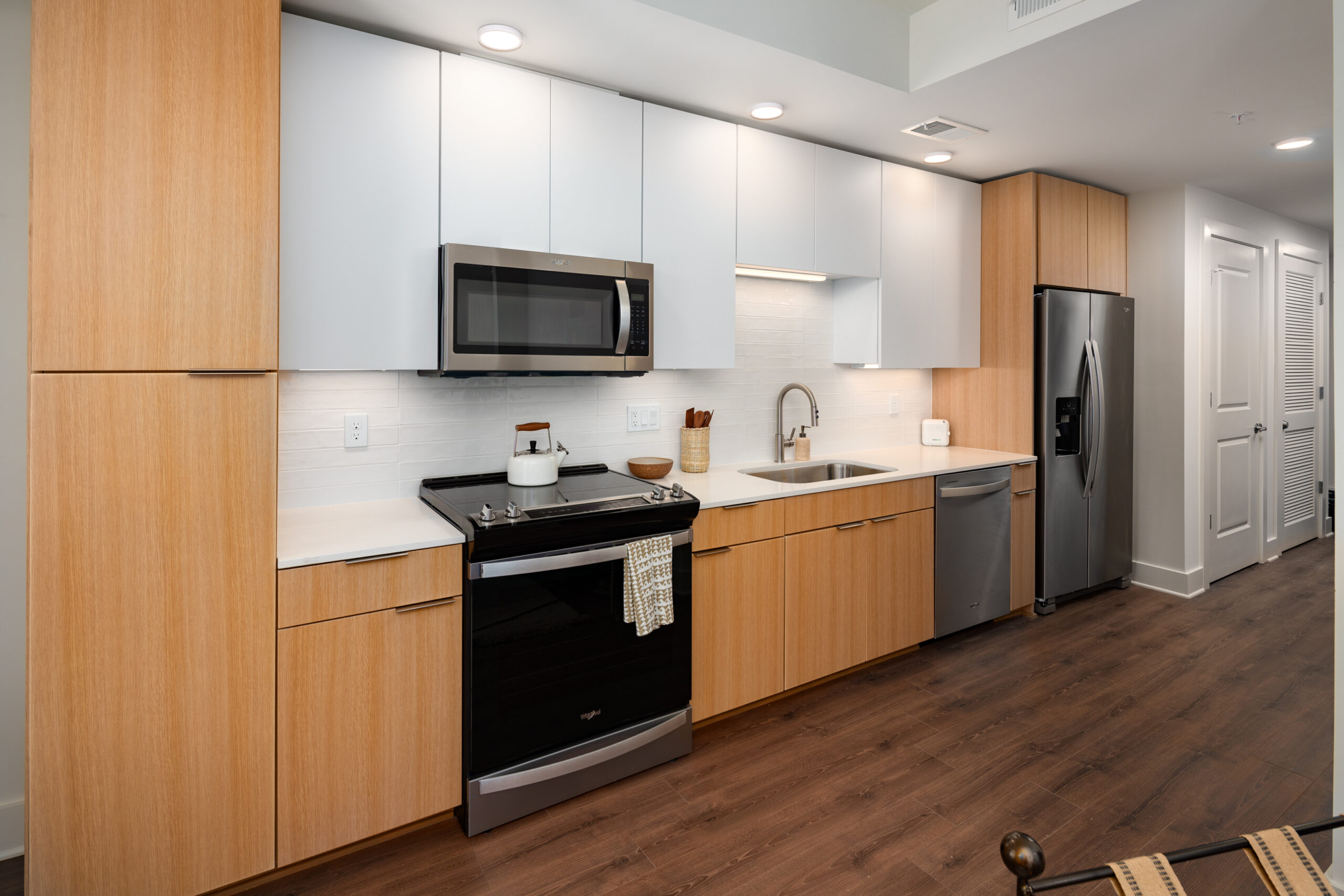 Model kitchen at our apartments for rent in Downtown Nashville, TN, featuring wood grain flooring and cabinetry.
