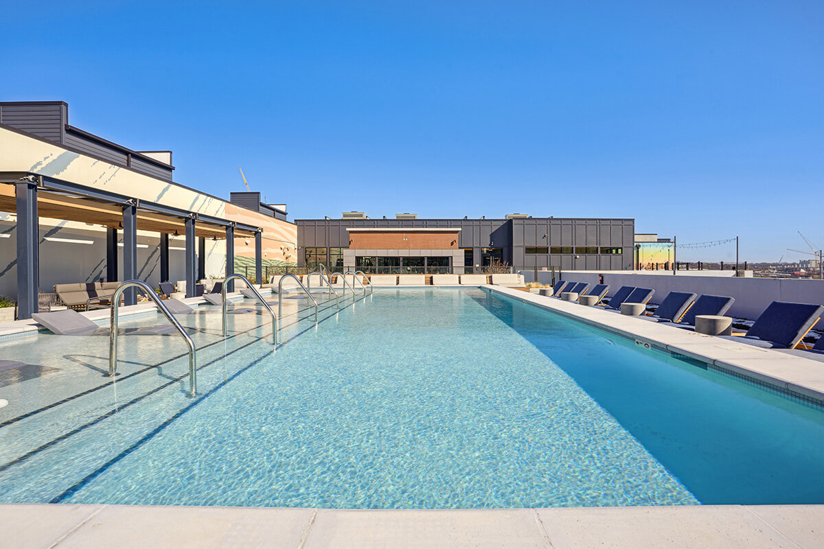 The rooftop pool at Starling apartments in Nashville, TN, including poolside recliner seating.